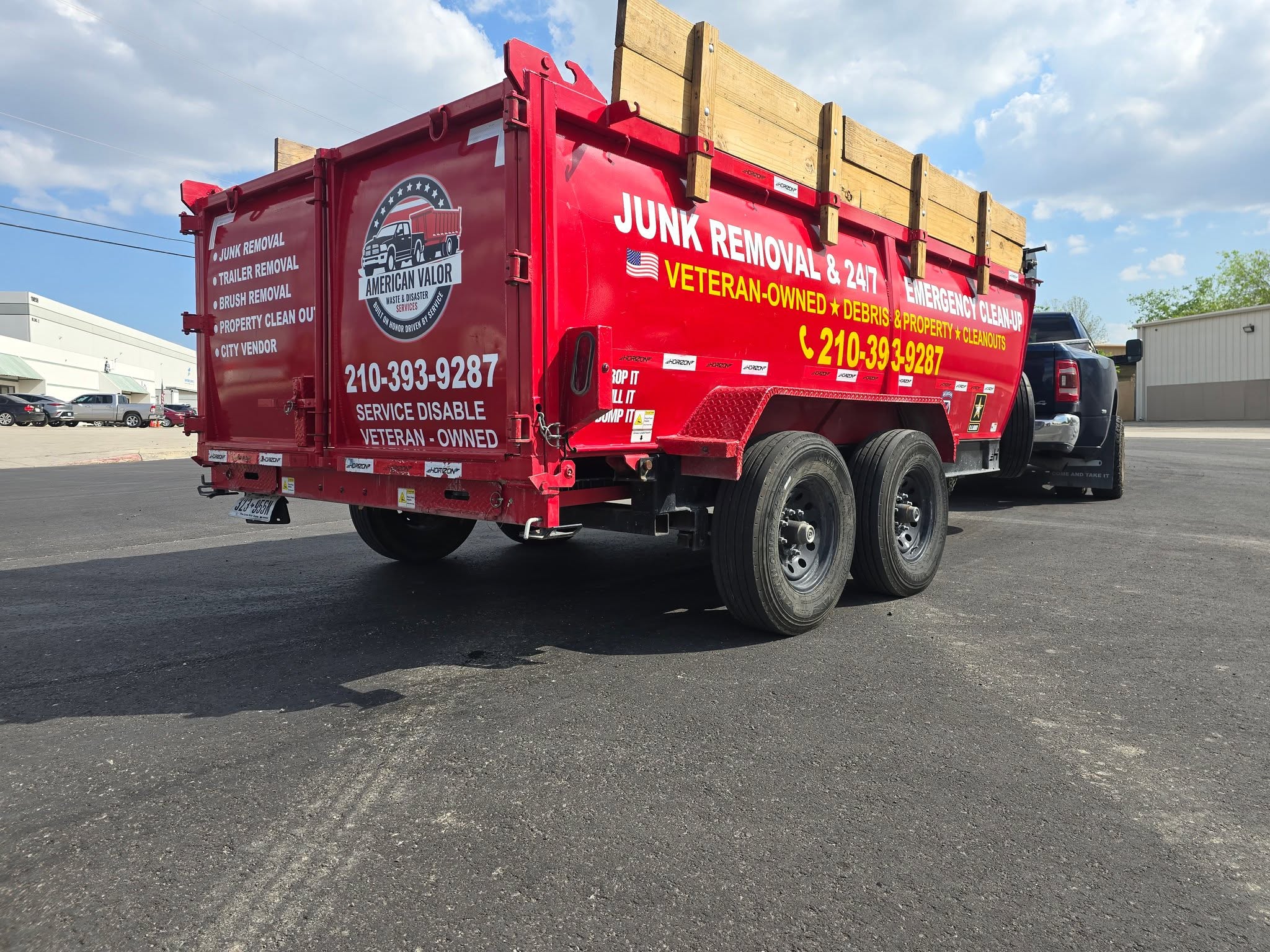 American Valor Waste service trailer listing junk removal, property cleanout, and brush removal services with contact number, San Antonio TX